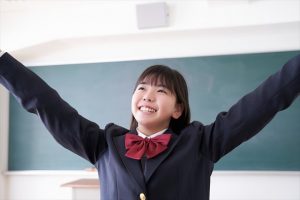 教室でバンザイをする日本人女子学生